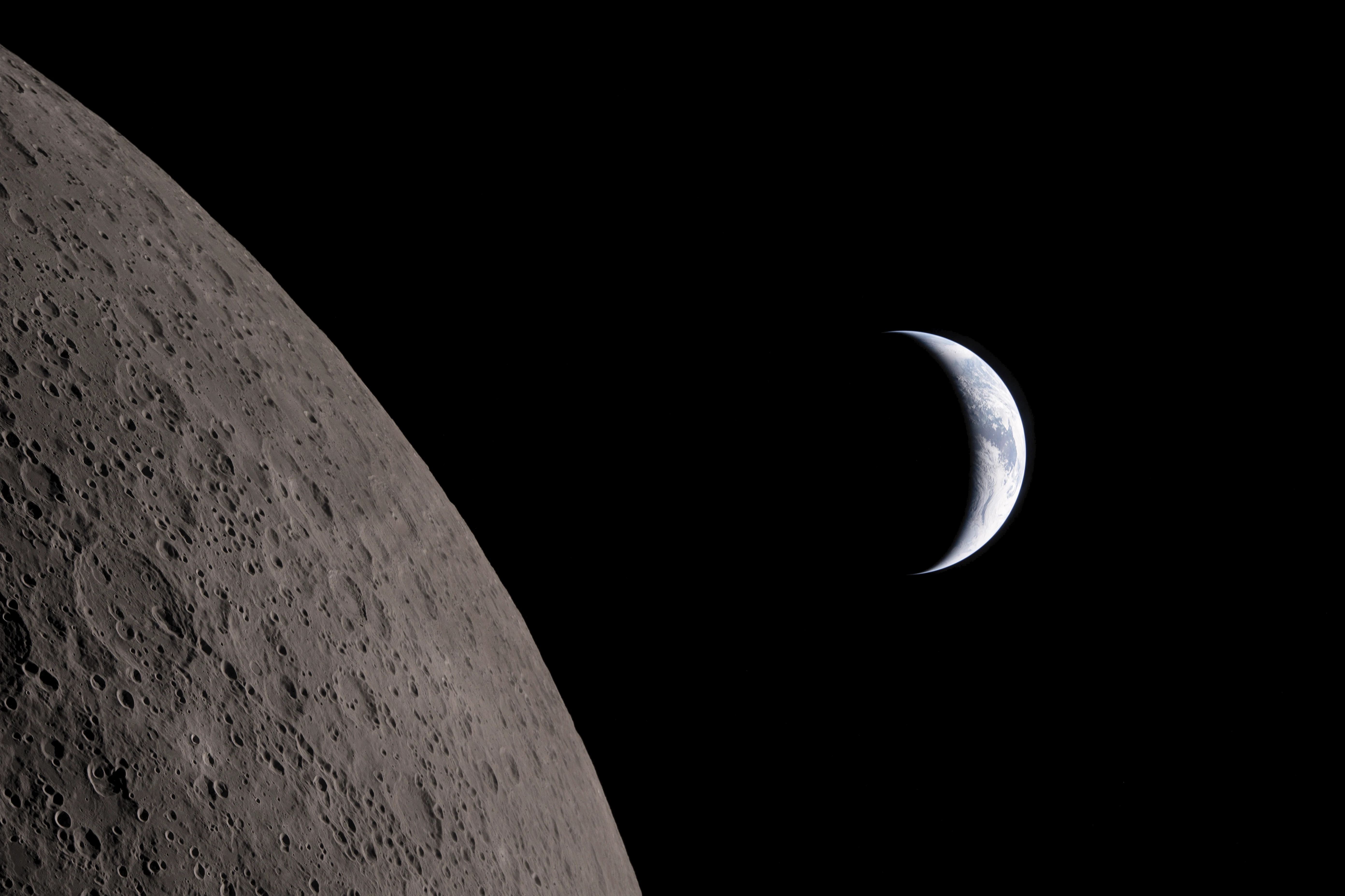 The Moon's cratered surface lit from below with Earth rising behind it, photographed during the Artemis II mission